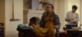 Movie still from “A Deadly Invitation” (2023), directed by J.M Cravioto – A man sitting on a chair with his eyes closed; Medium shot, Low angle