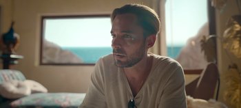 Movie still from “A Deadly Invitation” (2023), directed by J.M Cravioto – A person sitting at a table; Close Up shot, Low angle