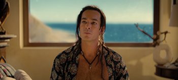 Movie still from “A Deadly Invitation” (2023), directed by J.M Cravioto – A man with long dreadlocks wearing a black shirt; Close Up shot, High angle