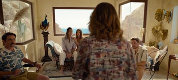 Movie still from “A Deadly Invitation” (2023), directed by J.M Cravioto – Two women sitting on a stool in front of a window; Wide shot, Over the shoulder angle