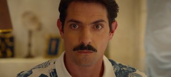 Movie still from “A Deadly Invitation” (2023), directed by J.M Cravioto – A person with a mustache; Close Up shot, Low angle