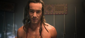 Movie still from “A Deadly Invitation” (2023), directed by J.M Cravioto – A person with dreadlocks in a room; Close Up shot, Over the shoulder angle