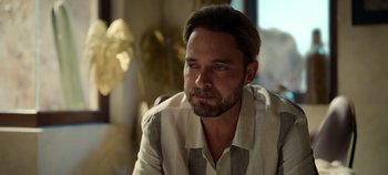 Movie still from “A Deadly Invitation” (2023), directed by J.M Cravioto – A person sitting in a room; Close Up shot, Over the shoulder angle