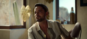 Movie still from “A Deadly Invitation” (2023), directed by J.M Cravioto – A man with a beard wearing a striped shirt; Close Up shot, Low angle