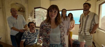 Movie still from “A Deadly Invitation” (2023), directed by J.M Cravioto – A woman standing in front of two other people; Medium shot, Over the shoulder angle