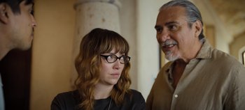 Movie still from “A Deadly Invitation” (2023), directed by J.M Cravioto – An older man standing next to a young woman; Close Up shot, Over the shoulder angle