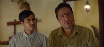 Movie still from “A Deadly Invitation” (2023), directed by J.M Cravioto – Two men standing next to each other in front of a wall; Close Up shot, Over the shoulder angle