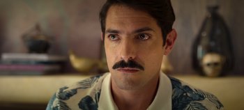 Movie still from “A Deadly Invitation” (2023), directed by J.M Cravioto – A person with a mustache; Close Up shot, Over the shoulder angle