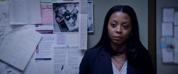 Movie still from “A Fall from Grace” (2020), directed by Tyler Perry – A woman standing in front of a wall with papers on the wall; Close Up shot, Over the shoulder angle
