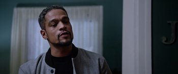 Movie still from “A Fall from Grace” (2020), directed by Tyler Perry – A person wearing a jacket; Close Up shot, Over the shoulder angle