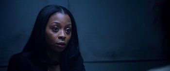 Movie still from “A Fall from Grace” (2020), directed by Tyler Perry – A woman with long black hair sitting in a dark room; Close Up shot, High angle