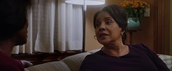 Movie still from “A Fall from Grace” (2020), directed by Tyler Perry – An older woman sitting on a couch in front of a window; Close Up shot, Over the shoulder angle