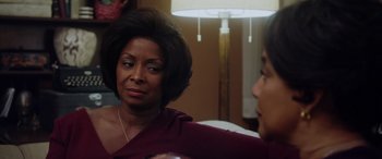 Movie still from “A Fall from Grace” (2020), directed by Tyler Perry – A woman sitting next to another woman in front of a lamp; Close Up shot, Over the shoulder angle