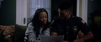Movie still from “A Fall from Grace” (2020), directed by Tyler Perry – A police officer and a woman looking at a laptop; Close Up shot, Over the shoulder angle