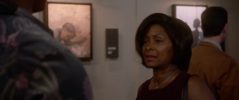 Movie still from “A Fall from Grace” (2020), directed by Tyler Perry – A woman standing in front of a painting; Close Up shot, Over the shoulder angle