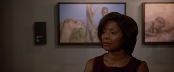 Movie still from “A Fall from Grace” (2020), directed by Tyler Perry – A woman standing in front of a picture of a cheetah; Close Up shot, Over the shoulder angle