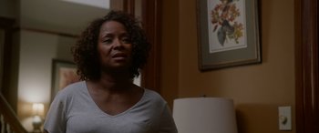 Movie still from “A Fall from Grace” (2020), directed by Tyler Perry – A woman standing in front of a lamp in a living room; Close Up shot, Over the shoulder angle