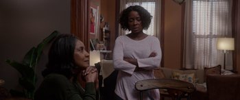 Movie still from “A Fall from Grace” (2020), directed by Tyler Perry – Two women are standing in a living room; Medium shot, Over the shoulder angle