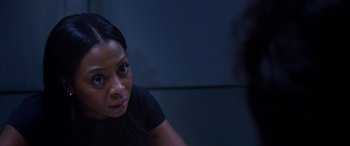 Movie still from “A Fall from Grace” (2020), directed by Tyler Perry – A woman sitting in front of a wall looking at the camera; Close Up shot, Over the shoulder angle