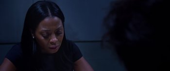 Movie still from “A Fall from Grace” (2020), directed by Tyler Perry – A woman sitting in front of a wall with her eyes closed; Close Up shot, Over the shoulder angle
