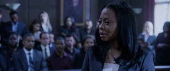 Movie still from “A Fall from Grace” (2020), directed by Tyler Perry – A woman standing in front of a group of people; Close Up shot, Over the shoulder angle