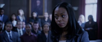 Movie still from “A Fall from Grace” (2020), directed by Tyler Perry – A woman standing in front of a group of people; Close Up shot, Over the shoulder angle