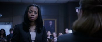 Movie still from “A Fall from Grace” (2020), directed by Tyler Perry – A woman standing in front of a group of people; Close Up shot, Over the shoulder angle