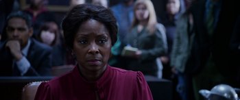 Movie still from “A Fall from Grace” (2020), directed by Tyler Perry – A woman in a red shirt is looking at the camera; Close Up shot, Over the shoulder angle