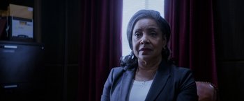 Movie still from “A Fall from Grace” (2020), directed by Tyler Perry – An older woman wearing a suit and looking at the camera; Close Up shot, Low angle