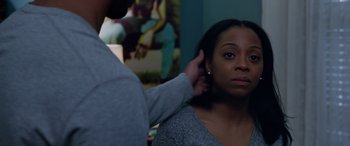 Movie still from “A Fall from Grace” (2020), directed by Tyler Perry – A woman looking in the mirror while a man puts something on her ear; Close Up shot, Over the shoulder angle