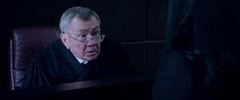 Movie still from “A Fall from Grace” (2020), directed by Tyler Perry – An older man wearing a black robe and glasses; Close Up shot, Over the shoulder angle