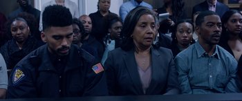 Movie still from “A Fall from Grace” (2020), directed by Tyler Perry – A group of people standing in a room; Medium shot, Over the shoulder angle