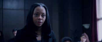 Movie still from “A Fall from Grace” (2020), directed by Tyler Perry – A woman with long black hair is standing in a dark room; Close Up shot, High angle