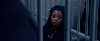 Movie still from “A Fall from Grace” (2020), directed by Tyler Perry – A woman sitting in a jail cell looking at the camera; Close Up shot, High angle