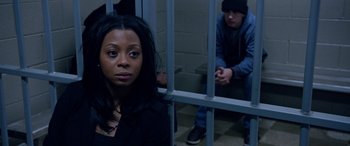 Movie still from “A Fall from Grace” (2020), directed by Tyler Perry – A woman sitting in front of a man in a jail cell; Close Up shot, High angle