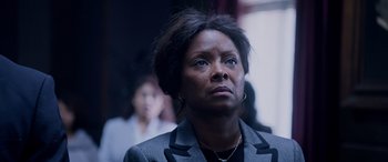 Movie still from “A Fall from Grace” (2020), directed by Tyler Perry – A woman in a gray jacket looking up; Close Up shot, Low angle