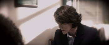 Movie still from “A Fall from Grace” (2020), directed by Tyler Perry – A woman in a black suit sitting in front of a window; Close Up shot, Over the shoulder angle