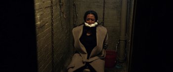 Movie still from “A Fall from Grace” (2020), directed by Tyler Perry – A woman with a mouth taped shut sitting on a chair; Medium shot, High angle