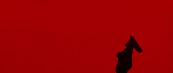 Movie still from “A Fistful of Dollars” (1964), directed by Sergio Leone – A person standing in front of a red wall; Close Up shot, Low angle