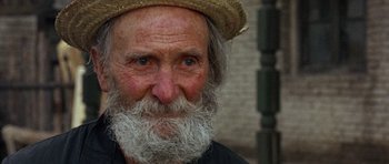 Movie still from “A Fistful of Dollars” (1964), directed by Sergio Leone – An old man with a beard wearing a straw hat; Close Up shot, Over the shoulder angle