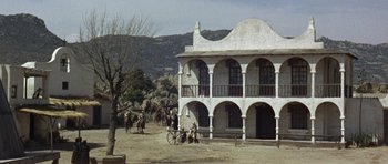 Movie still from “A Fistful of Dollars” (1964), directed by Sergio Leone – A group of people riding horses in front of a building; Extreme Wide shot, Low angle
