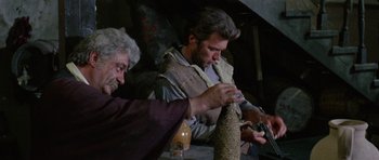 Movie still from “A Fistful of Dollars” (1964), directed by Sergio Leone – A man and an old man working on a project together; Medium shot, Low angle