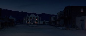 Movie still from “A Fistful of Dollars” (1964), directed by Sergio Leone – An empty street at night with a building in the background; Extreme Wide shot, Low angle