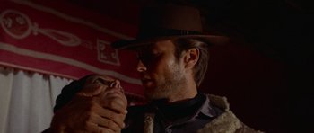 Movie still from “A Fistful of Dollars” (1964), directed by Sergio Leone – A man in a cowboy hat holding a woman's hand; Close Up shot, Low angle