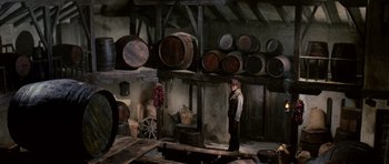 Movie still from “A Fistful of Dollars” (1964), directed by Sergio Leone – A man standing in a room full of barrels; Wide shot, High angle
