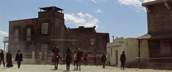 Movie still from “A Fistful of Dollars” (1964), directed by Sergio Leone – A group of men riding horses in a dirt field; Extreme Wide shot, Low angle