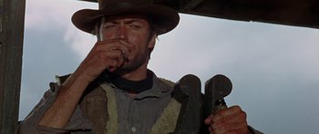 Movie still from “A Fistful of Dollars” (1964), directed by Sergio Leone – A man holding a wrench and smoking a cigarette; Close Up shot, Low angle