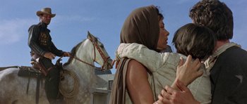 Movie still from “A Fistful of Dollars” (1964), directed by Sergio Leone – A woman is hugging a horse in the background; Close Up shot, Low angle