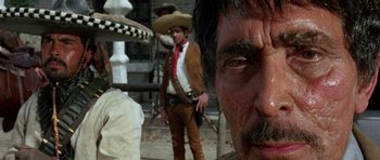 Movie still from “A Fistful of Dollars” (1964), directed by Sergio Leone – A man with a mustache and a hat is looking at the camera; Close Up shot, Low angle