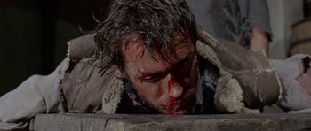 Movie still from “A Fistful of Dollars” (1964), directed by Sergio Leone – A person with blood on his face; Close Up shot, Overhead angle